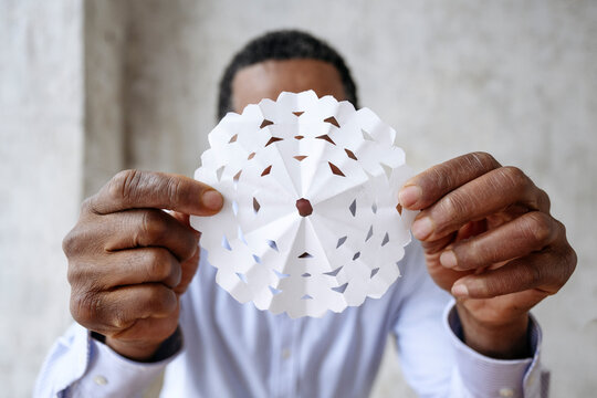 Mature man showing paper snowflake