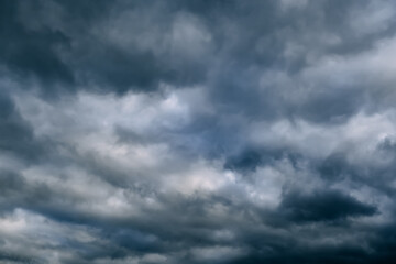 Fototapeta premium A dark blue cloudy sky. Cumulus clouds. Nature background. Bad weather forecast. Before a thunderstorm, hurricane or storm. The power and strength of nature. Air element. Wallpaper. Moving ciclone