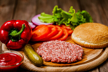 Closeup of ingredients for burger with artificial meat and vegetables on wooden board. Plant based 