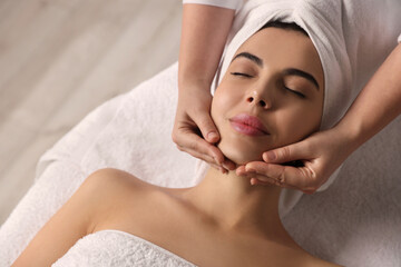 Beautiful woman receiving facial massage in beauty salon, closeup