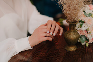 Fototapeta na wymiar Bride and groom hands with wedding ring