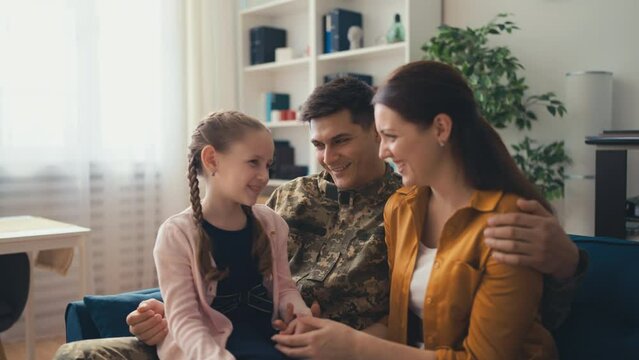 Happy military man spending time home with his wife and daughter, family reunion
