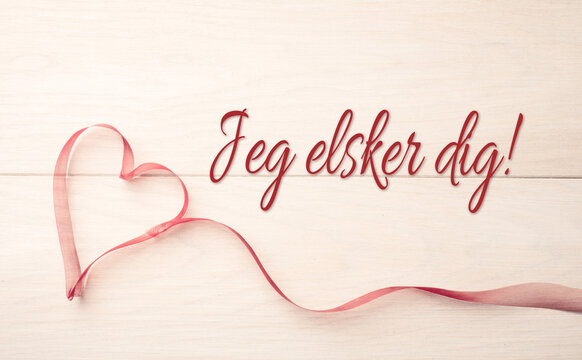 Ribbon in the shape of a heart on a light wooden table, Jeg elsker dig, Scnadinavian I love You