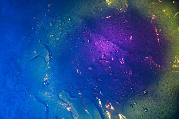 Fototapeta na wymiar water texture in the form of drops with colored highlights of purple blue and yellow