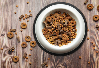 A bowl of dog food on a wooden floor.