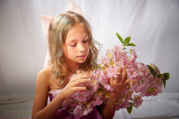 Portrait of cute kid girl posing in pink beautiful dress on a white background. Model in studio looking as gentle magic princess from fairy taly