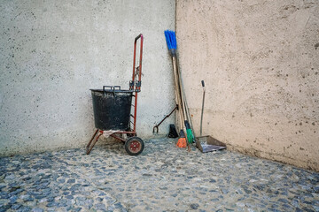Garbage bag with wheel and broom with shovel on construction site