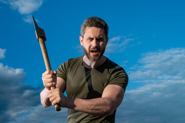 man threaten with axe. shouting man hold ax. brutal man on sky background