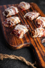 smoked dates in bacon snack meat dry-cured meal food snack on the table copy space food background rustic top view