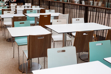 Empty tables and chairs in shopping center white brown and turquoise color 