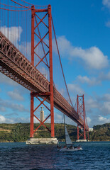 The "25 de Abril" suspension bridge (which translates to the "25th of April" Bridge) and the 'Cristo Rei' (which translates to "Christ the King") 
statue on the banks of the Tagus River in the capital