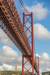 The "25 de Abril" suspension bridge (which translates to the "25th of April" Bridge) and the 'Cristo Rei' (which translates to "Christ the King") 
statue on the banks of the Tagus River in the capital