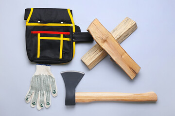 Ax with firewood, bag and gloves on color background