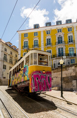 Fototapeta na wymiar The graffiti covered yellow Funicular railway in Lisbon, Portugal