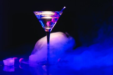 Martini cocktail drink splash with ice cubes in neon iridescent pink and blue colors. Minimal night...