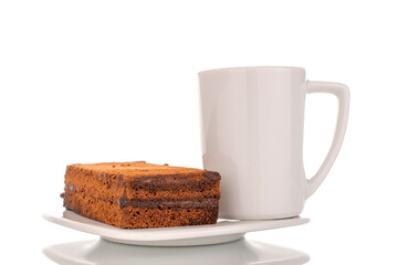 One piece of truffle cake on a ceramic white saucer and cup, macro shot on a white background.