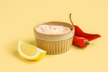 Bowl of tasty chipotle sauce on yellow background
