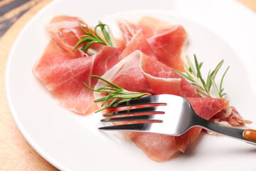 Plate with slices of tasty ham and rosemary, closeup
