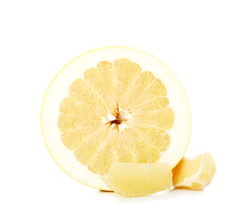 Half and slices of sweet pomelo fruit on white background