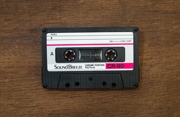 Sound breeze audio cassette on a wooden table.A tape recorder for listening to music. A vintage way...
