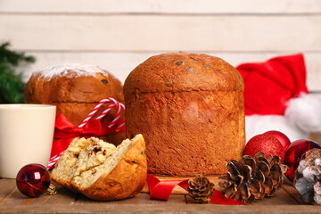 Tasty Panettone with Christmas decor on wooden table, closeup