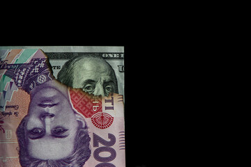 American and Ukrainian currencies on a black background