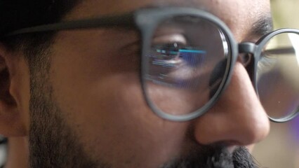 Close-up view of glasses with reflection of binary code on computer. Young caucasian professional programmer coding typing working on IT company developing using technologies in office. - Powered by Adobe
