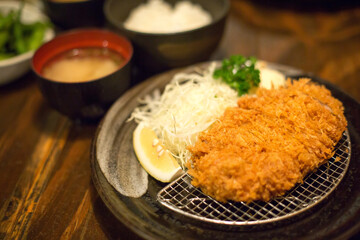 Selective focus of Tonkatsu set on wooden table in Japanese restaurant