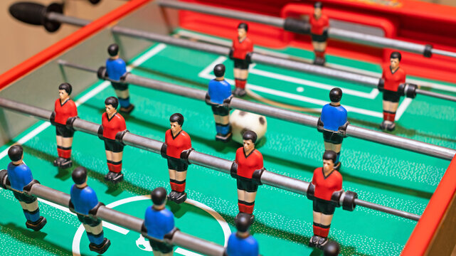 Starting a table football game. Young people playing table football.
