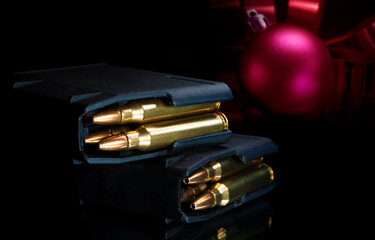 Red Christmas ornament behind loaded magazines