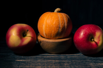 Pumpkin with apples on a black background.