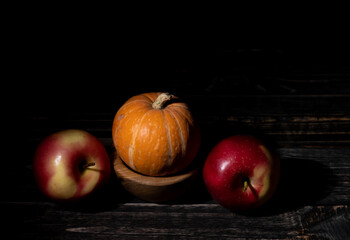 Apples and pumpkin on a black background.