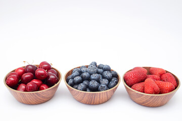 Blueberries, strawberries and cherry on white background with free space