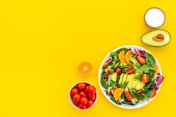 Healthy vegetarian lanch with bowl of green salad with avocado and tomatoes