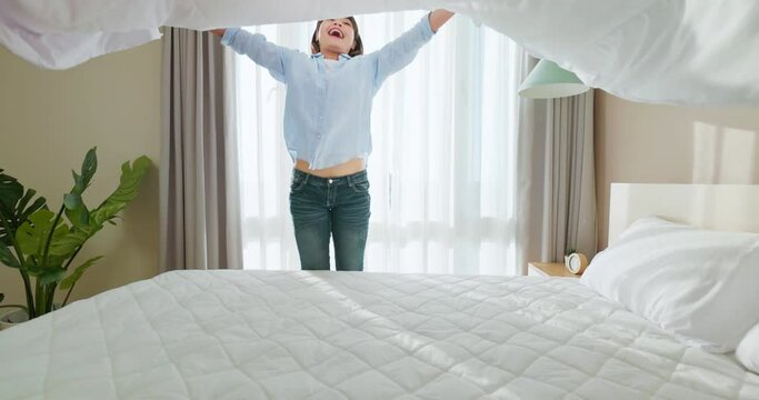 woman changes bed quilt