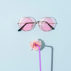 Image of a young woman's face with tube glasses on a blue background. Summer weekend or holiday concept.