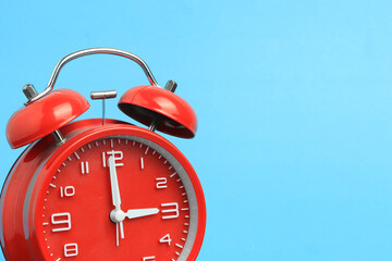 red alarm clock on a blue background
