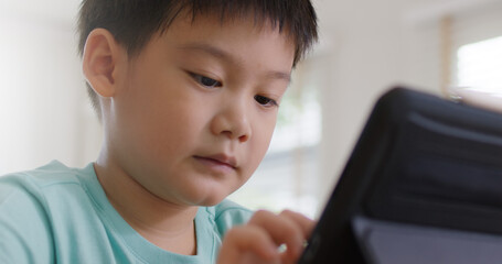 Cute asia people alpha Gen Z kid small boy happy play video game app online at home. Enjoy fun class little child care study learn upskill idea course look at touch screen smart tech digital tablet.