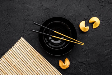 Asian style tabble place setting with fortune cookies and golden chopsticks