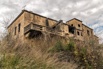 Fototapeta na wymiar old abandoned building against cloudy sky