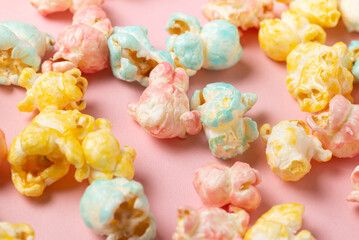 Colored glazed popcorn scattered on pink background