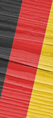 Flag of Germany on dry cracked wooden surface. Phone wallpaper with German national symbol. Hard sunlight with shadows on old wood. Vertical vintage background. Aspect ratio 9:20