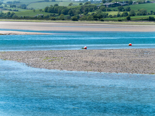 A sandbank at low tide on a spring day. The sea water is a beautiful turquoise color. Sea coast, landscape.