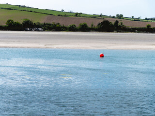A buoy on the water on a sunny day. Seaside Irish landscape, body of water.