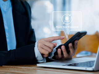 Reset password concept. Lock icon, security code showing on smart mobile phone in hands of business person while working with laptop computer in office. Cyber security technology on website or app.