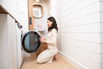 Happy Asian young woman is doing laundry in home , healthy lifestyle concept