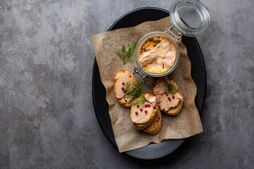 Plate with baguette toast with foie gras pate, directly above. A specialty food product made of the liver of a duck or goose,  in a glass jar. Decorated with red pepper and dill. - obrazy, fototapety, plakaty