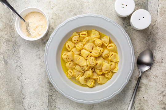 Tortellini In Beef And Chicken Broth. Egg Pasta Originally From The Italian Region Of Emilia, Bologna. Stuffed With A Mix Of Meat, Prosciutto, Mortadella, Hard Cheese, Egg And Served In Capon Broth.