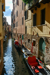 Fototapeta na wymiar View of a Venetian canal with moored gondolas, Venice, Italy