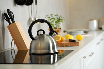 Stylish kettle with whistle on cooktop in kitchen. Space for text